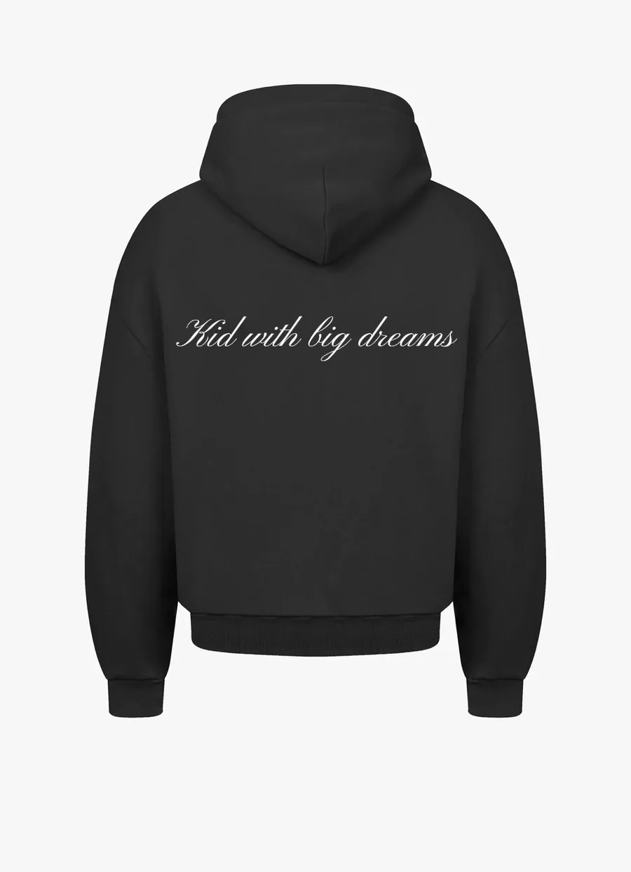 De rug van hetzelfde zwarte vest, met in schuinschrift de regel Kid with big dreams.